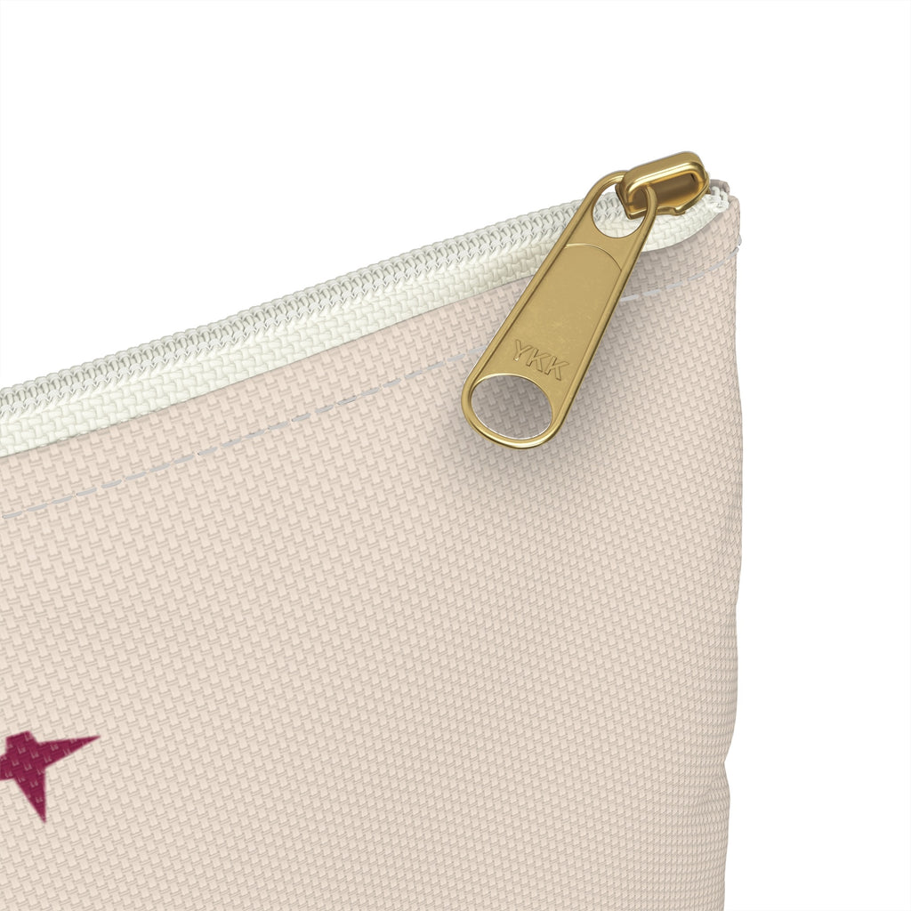 White zipper and gold puller close-up on cream makeup bag