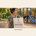 Woman carrying the Sideline Snack Mom tote in a park