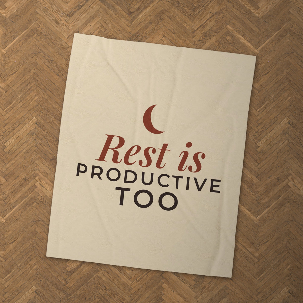 Rest Is Productive Too blanket on a herringbone wood floor