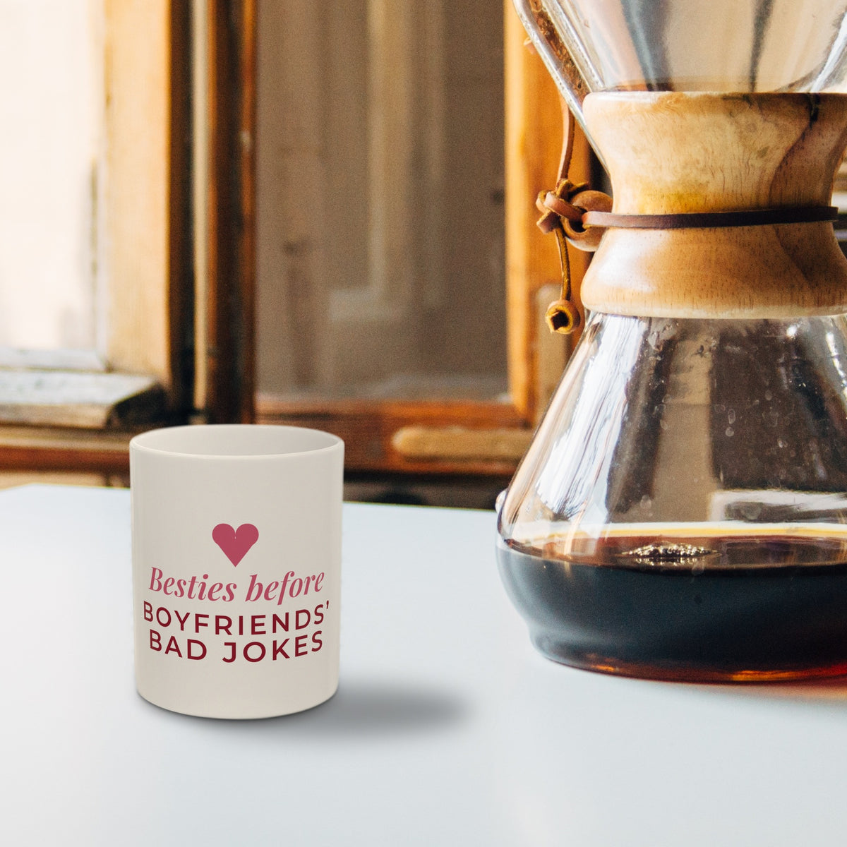 Besties Before Boyfriends Bad Jokes mug beside a Chemex coffee maker