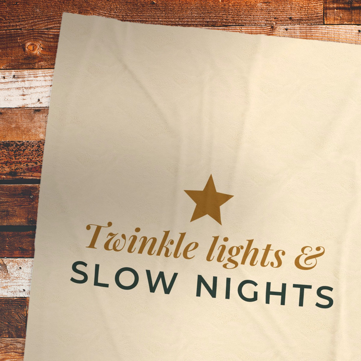 Twinkle Lights and Slow Nights blanket on a wood plank floor