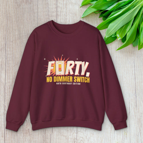 Forty No Dimmer Switch crewneck in maroon laid flat beside green leaves