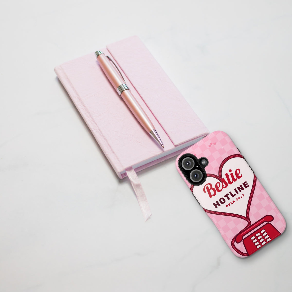 Bestie Hotline phone case styled on marble with pink journal